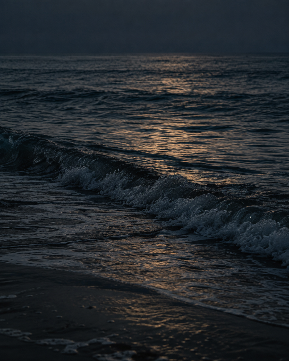 Dark waves catching the last amber light